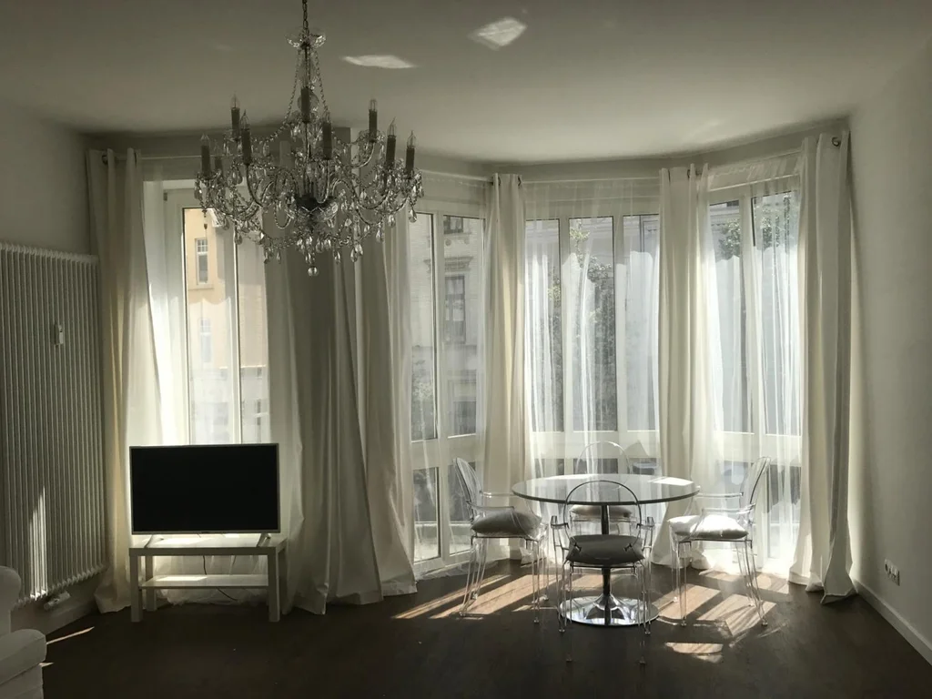 Wohnzimmer mit Kronleuchter und Esstisch – Ferien Apartment